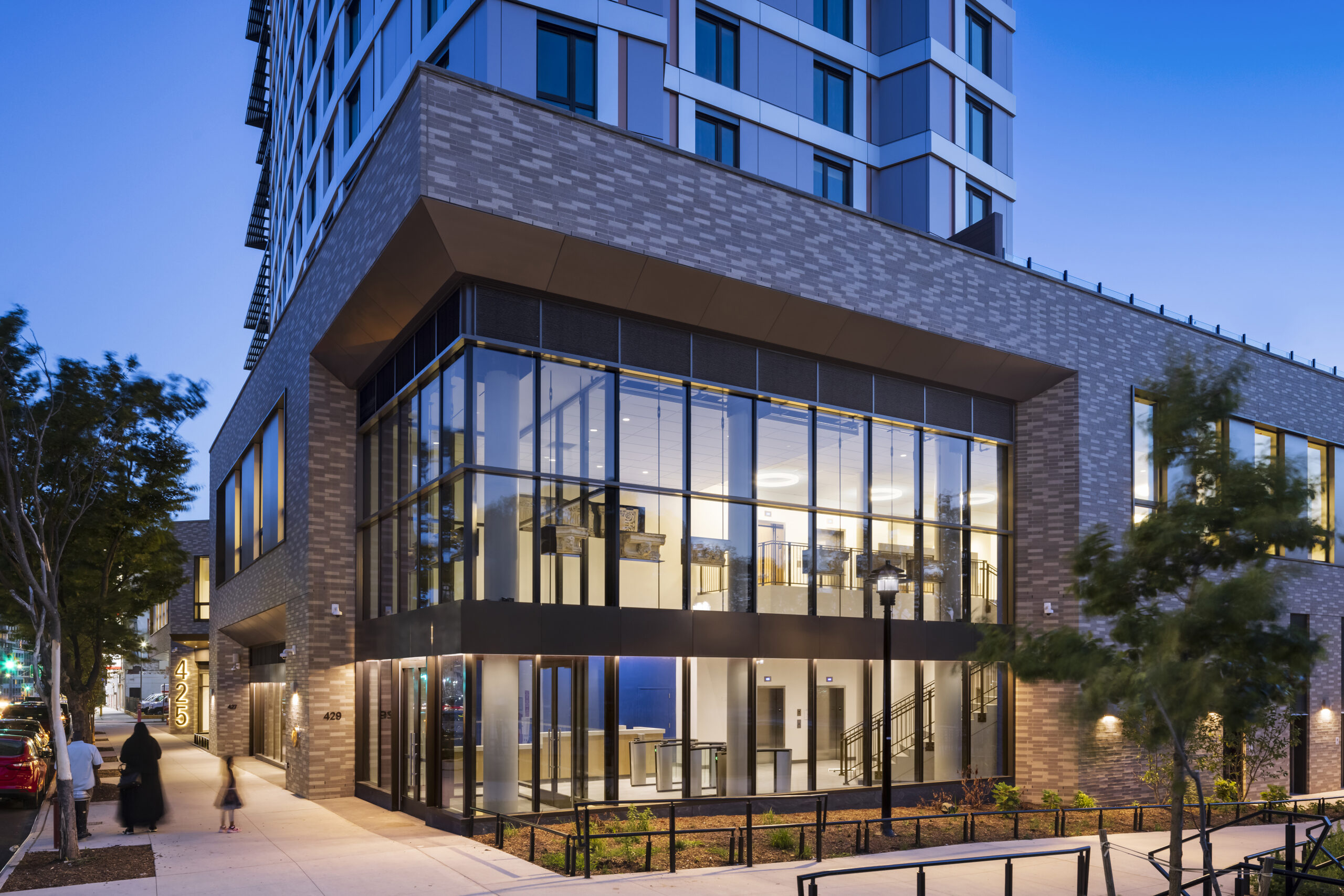 425 Grand Concourse entrance and double-height lobby with integrated architectural lighting visible through the glass facade.