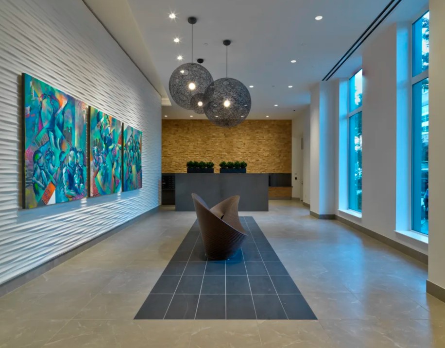 425 Grand Concourse residential lobby with decorative pendant fixtures, recessed downlighting, and integrated cove lighting.