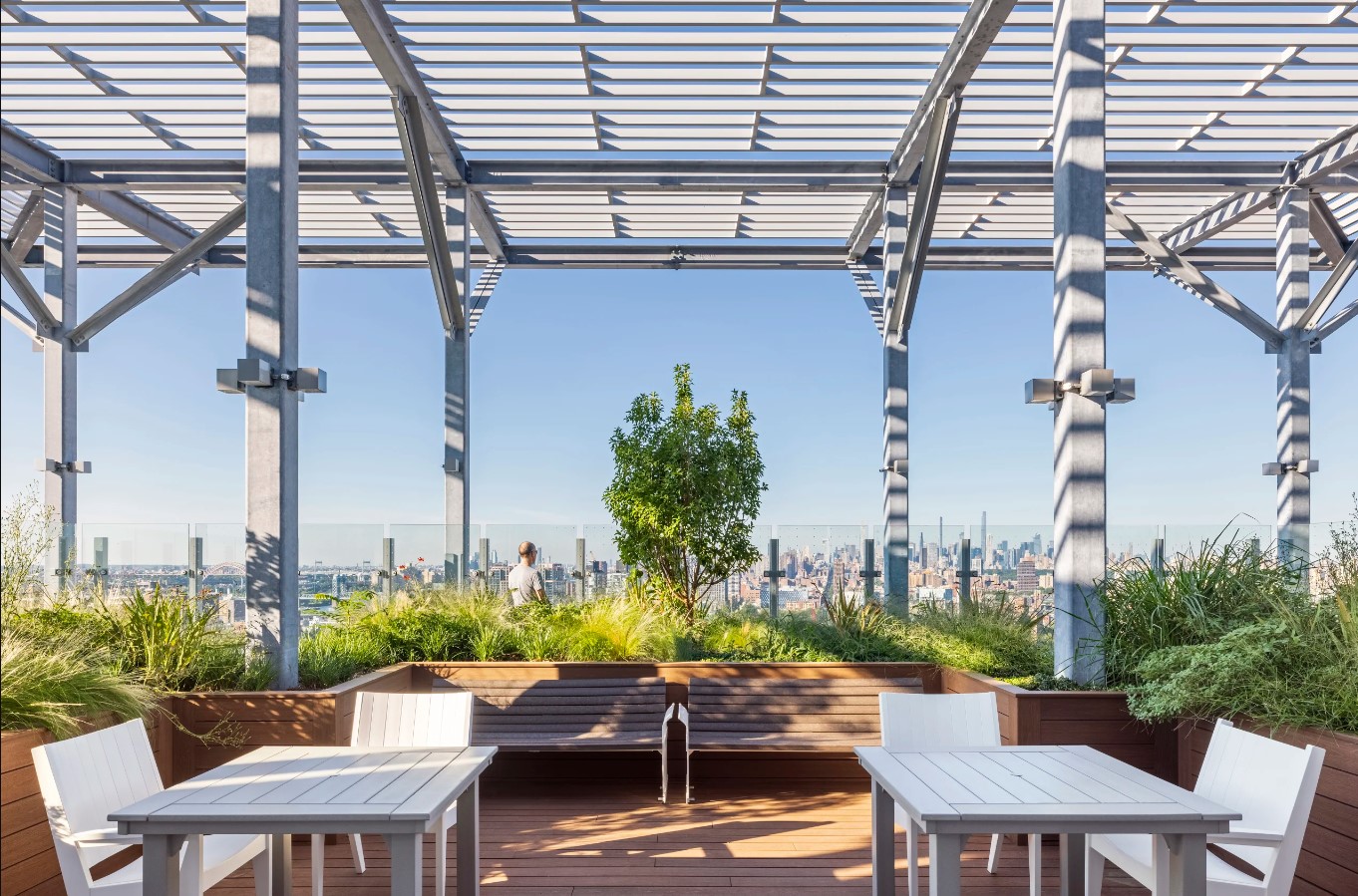 425 Grand Concourse rooftop terrace with landscaped seating areas and views of the Manhattan skyline.