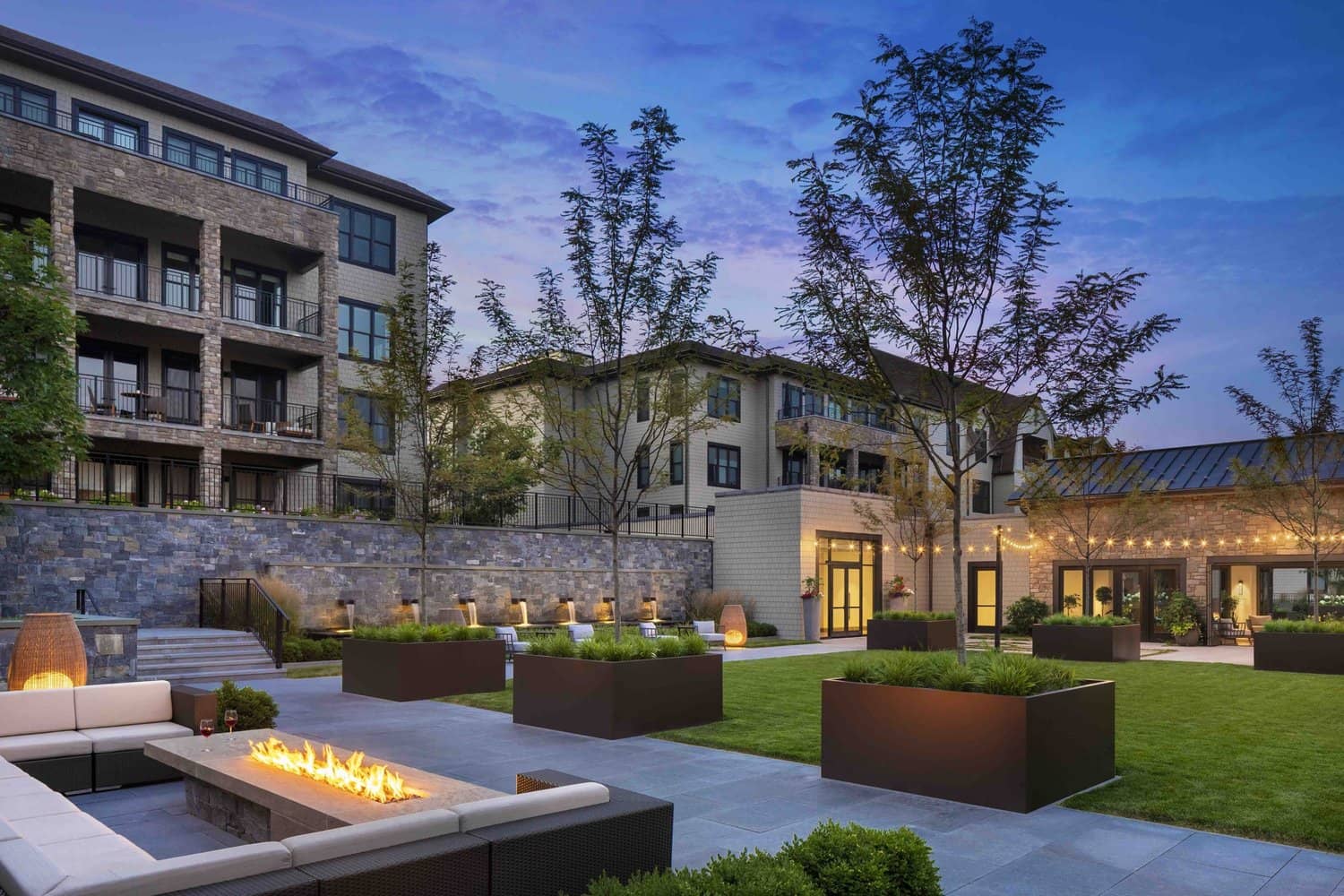 Rooftop outdoor space with seating and accent lighting at dusk.