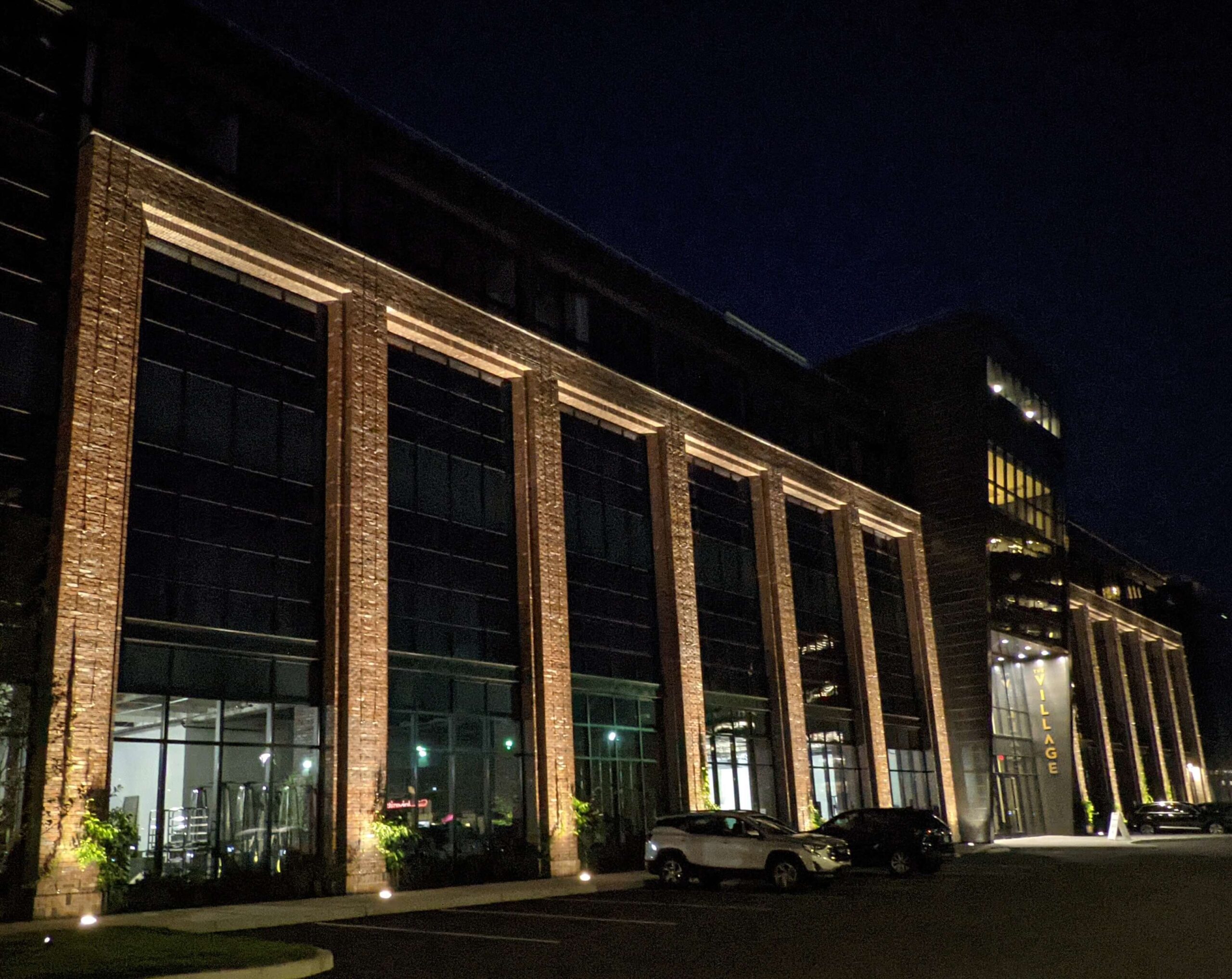 The Village in Stamford, CT with uplighting on brick columns between curtain windows.