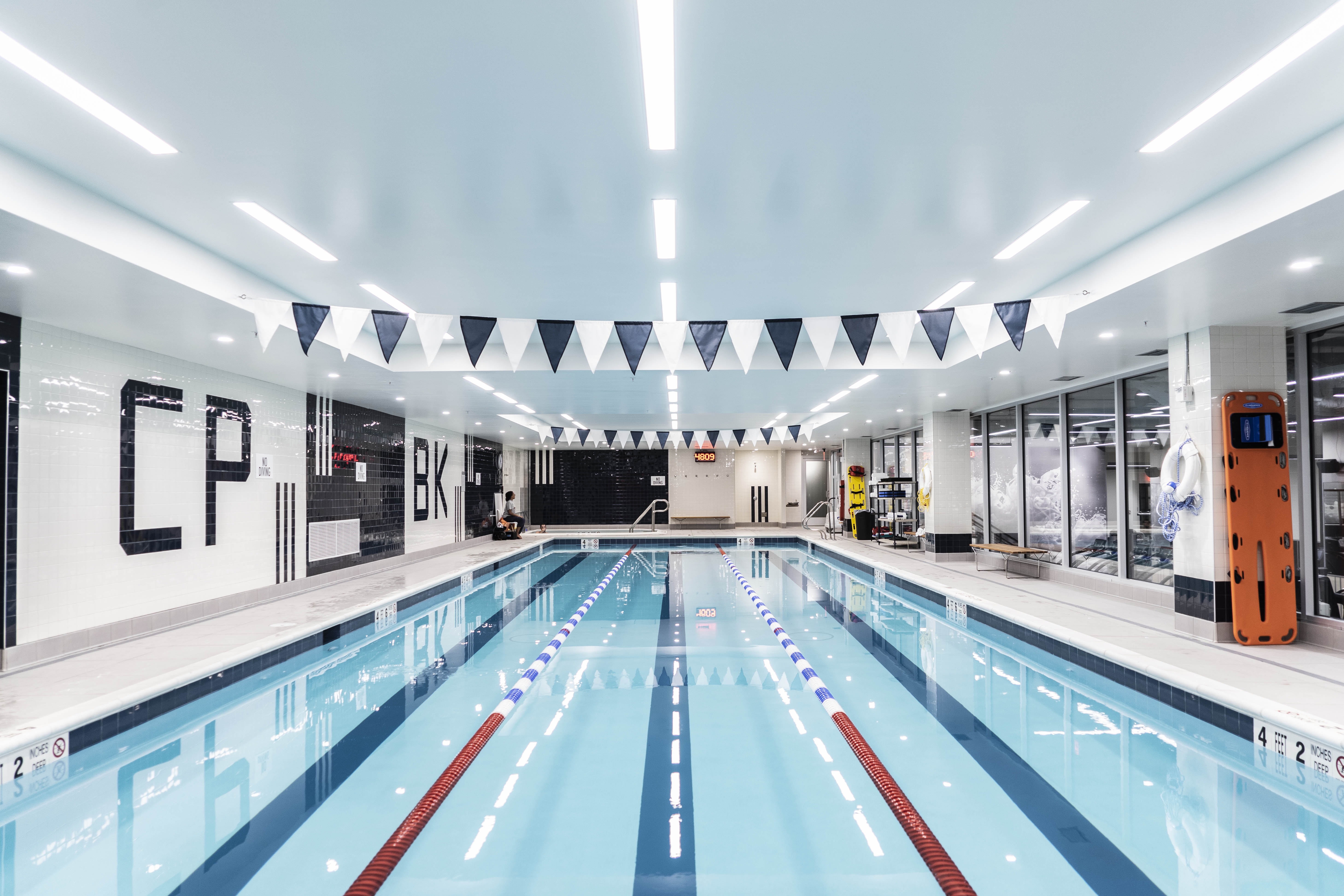 Swimming pool with overhead lighting that follows the direction of the lanes.