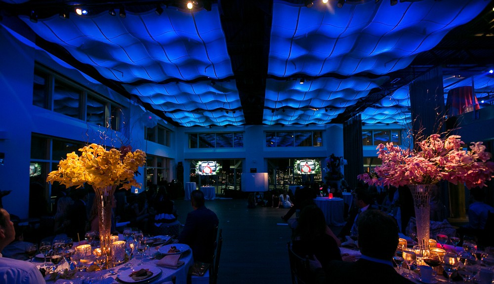 Hotel hospitality space with dramatic blue lighting with spotlight warm orange detail lighting.
