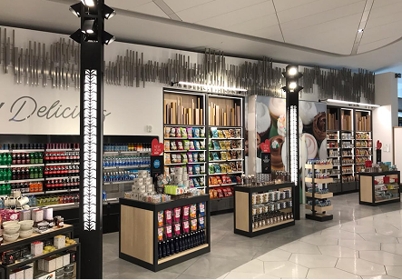 Retail displays at Bowery Bay Shops at LaGuardia Airport illuminated by adjustable accent lights mounted on custom lighting towers.