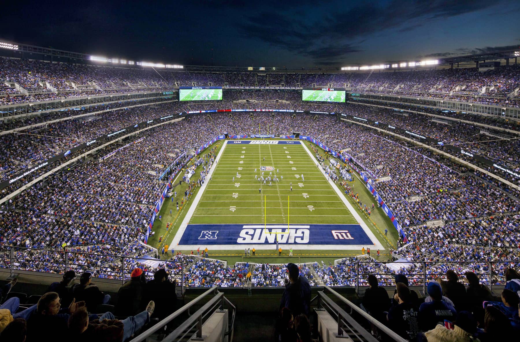 Met Life Stadium field with stadium lights above the field and crowd.
