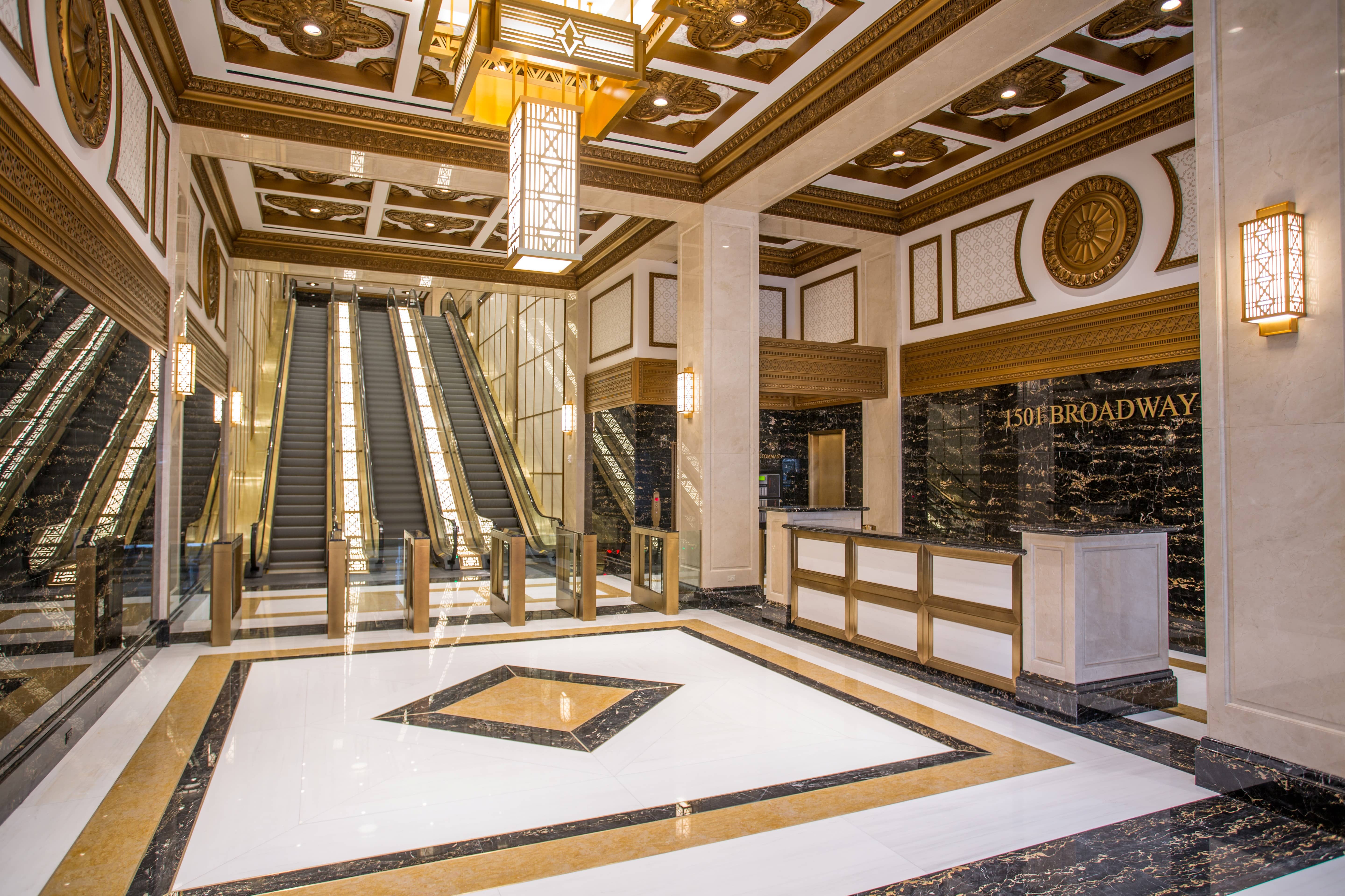 Elaborate lobby with marble floors and ornate ceiling treatment with centerpiece chandelier.
