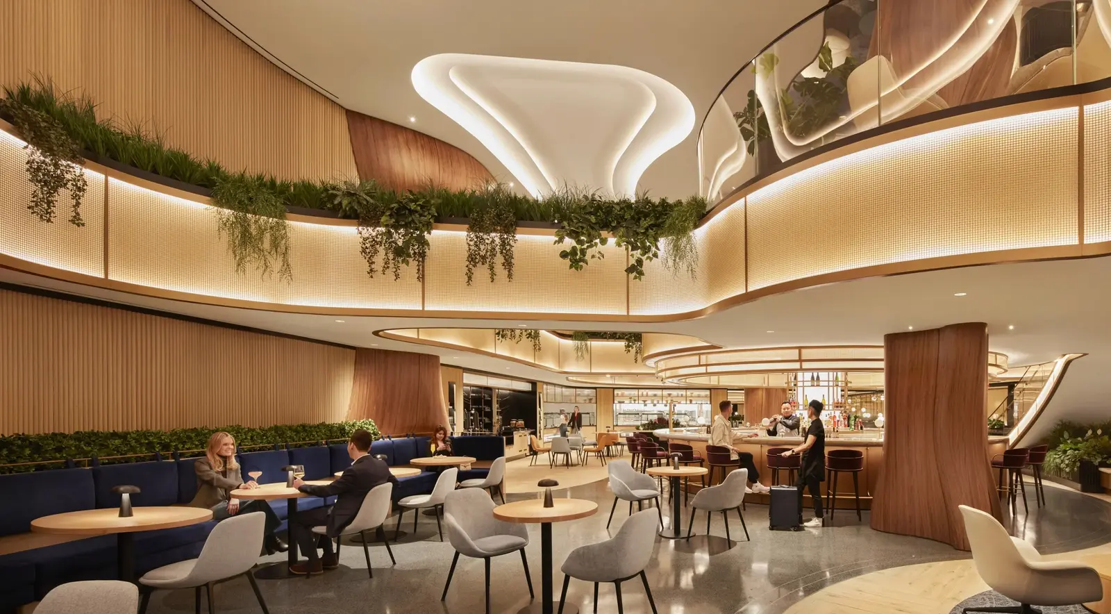 Airport lounge with layered architectural lighting integrated into curved ceilings, illuminated railings, bar, and seating areas.