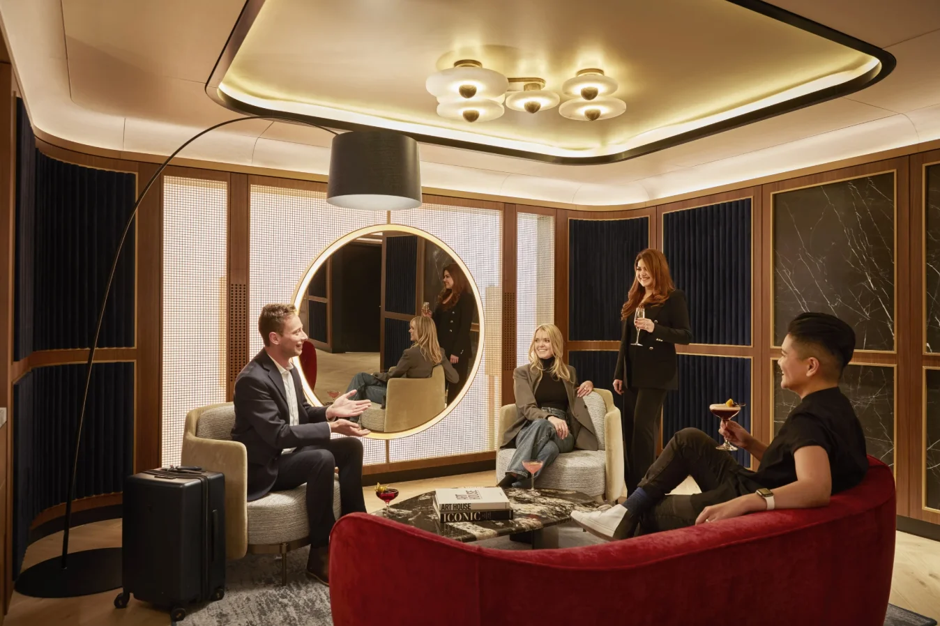 Private suite within an airport lounge with layered cove lighting, decorative ceiling fixtures, and illuminated architectural details.
