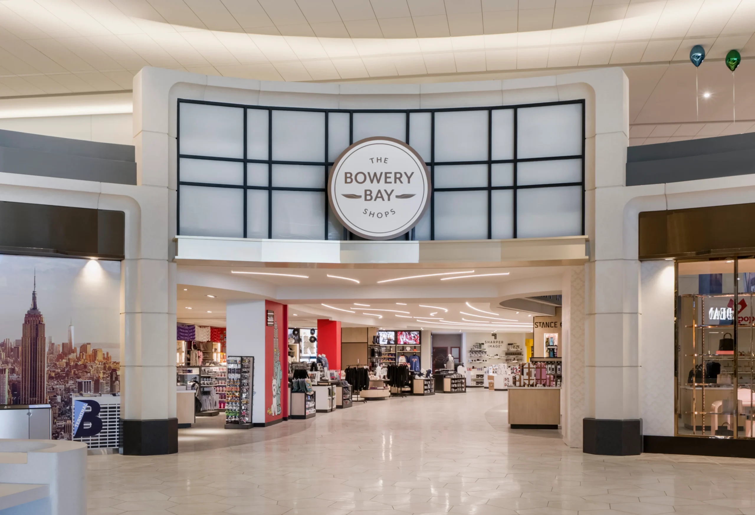 The Bowery Bay Shops retail entrance with integrated architectural lighting at an airport terminal.
