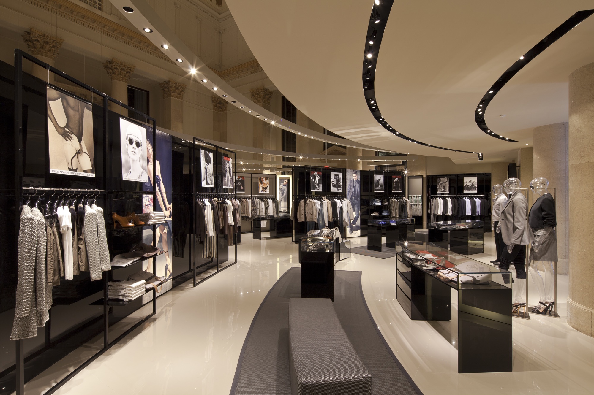 Custom concentric steel lighting arcs with adjustable accent lights illuminating Emporio Armani merchandise.
