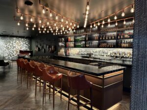 Wheelhouse bar with exposed-bulb pendant grid and integrated shelf lighting