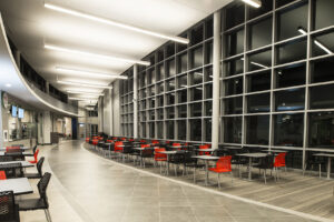 Stony Brook University East Side Dining with linear lighting following the curved ceiling above student seating.